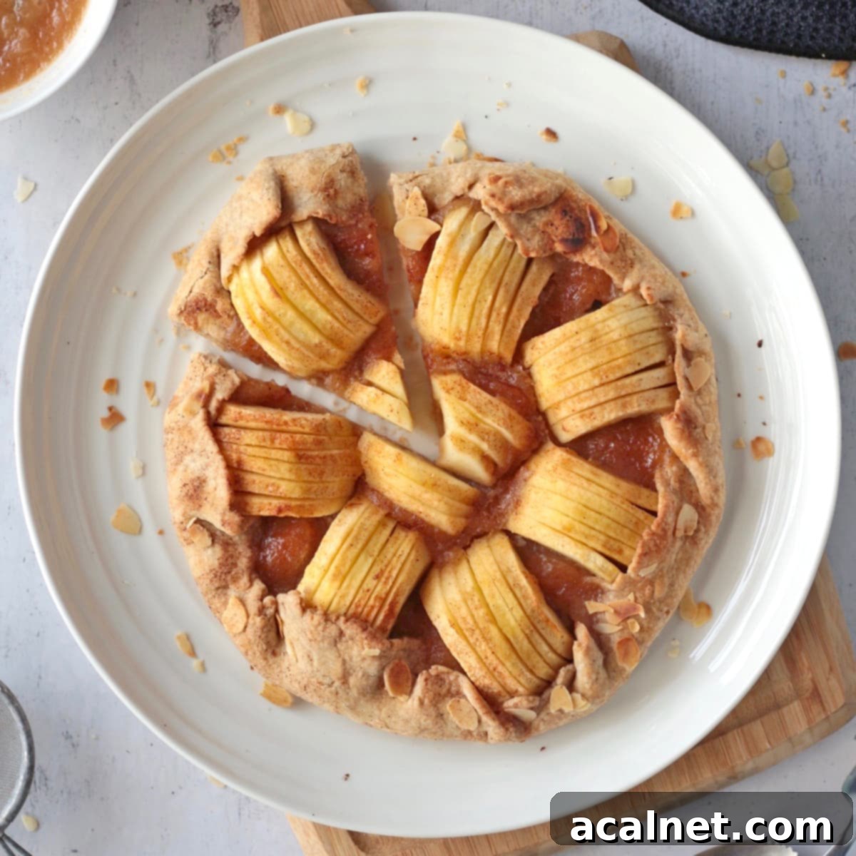 Beautiful flat lay of a rustic apple galette with a cinnamon crust and artfully arranged apple slices, a perfect dessert for fall and winter.
