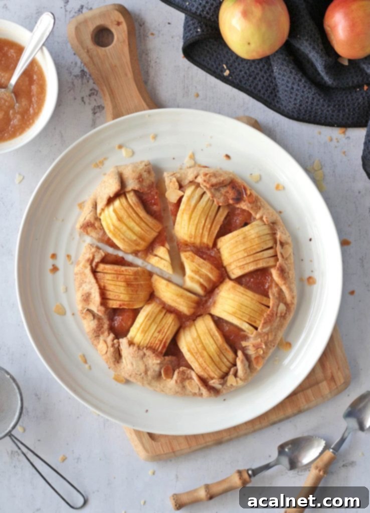 Overhead view of a perfectly baked apple galette with one slice cut out, showcasing its rustic beauty and inviting apple filling.