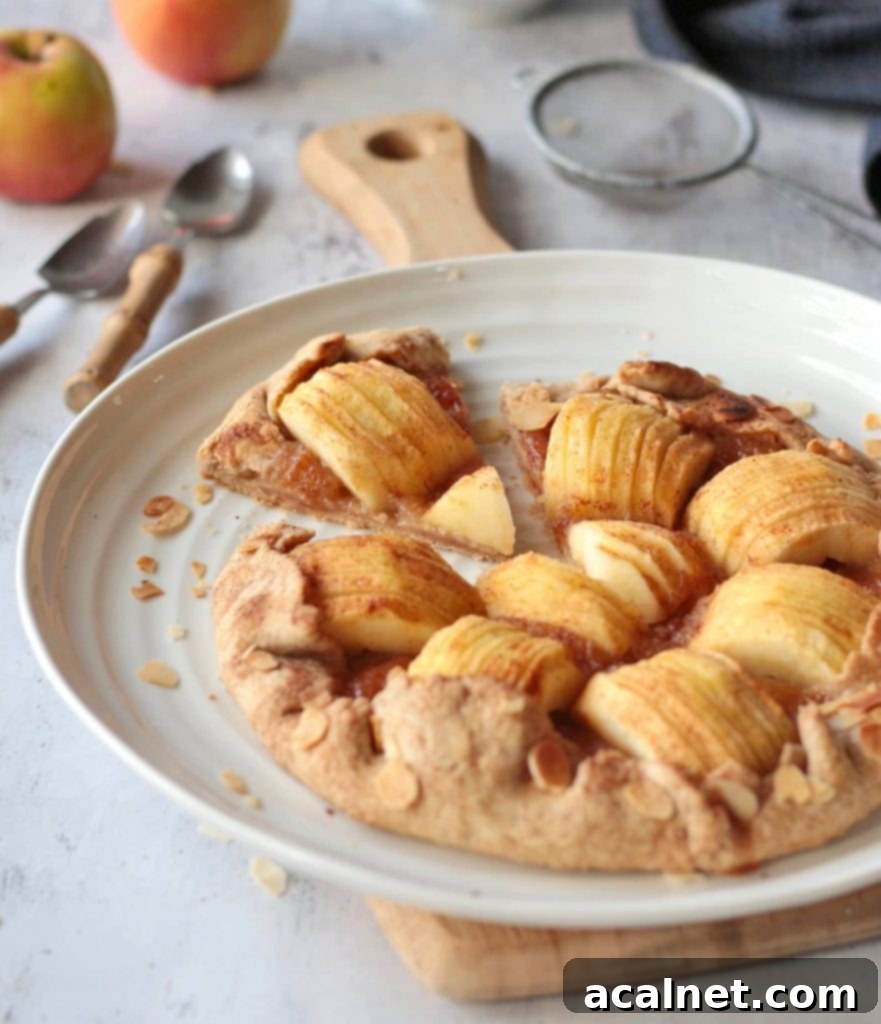A delicious slice of rustic apple tart cut out and placed on a white plate, highlighting the flaky crust and juicy apple filling.