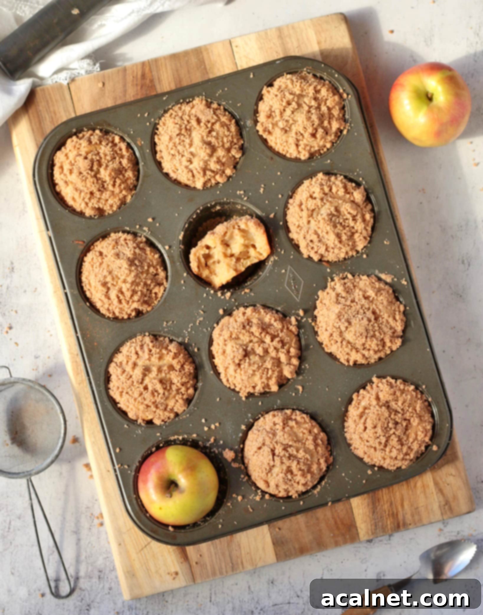 Heavenly Apple Cinnamon Streusel Muffins 4 Warm streusel-topped apple cinnamon muffins cooling in the baking pan, viewed from above.