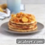Banana Pancakes stacked on a grey plate and topped with honey caramelised bananas.