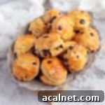 Freshly baked chocolate chip scones with a dark chocolate drizzle on a grey serving plate, ready to be enjoyed.