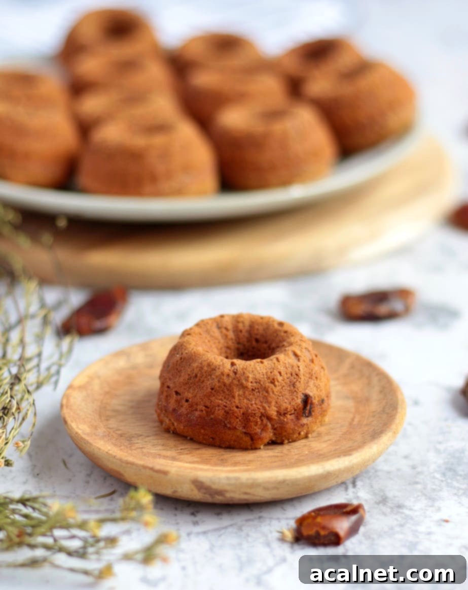 One sticky date pudding on a wooden plate.