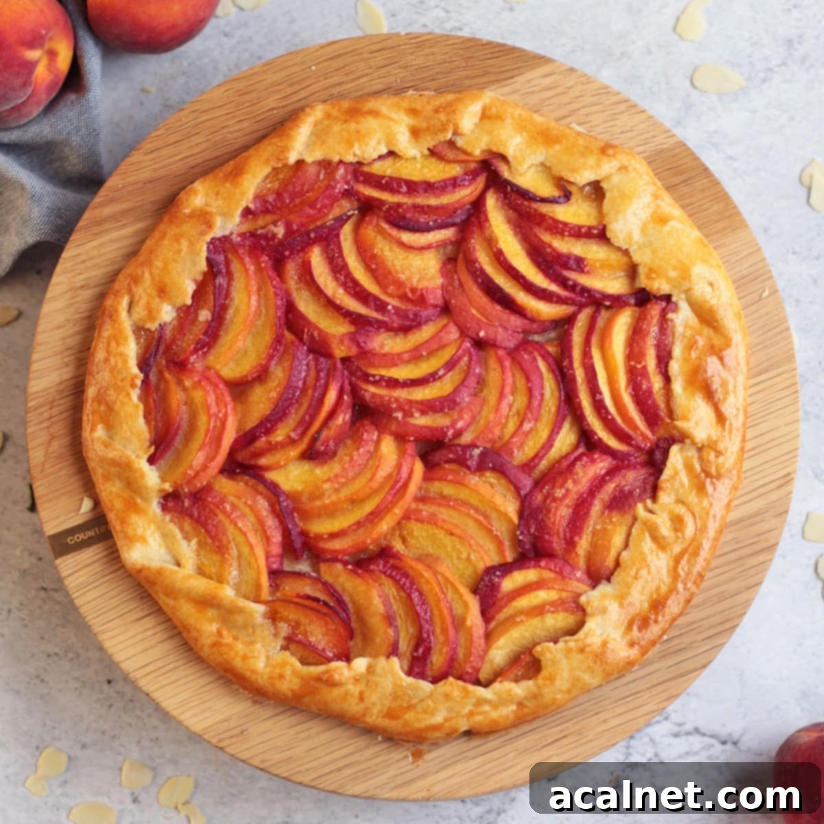Almond Peach Galette from above on a wooden stand, showcasing its rustic charm and golden-brown crust.