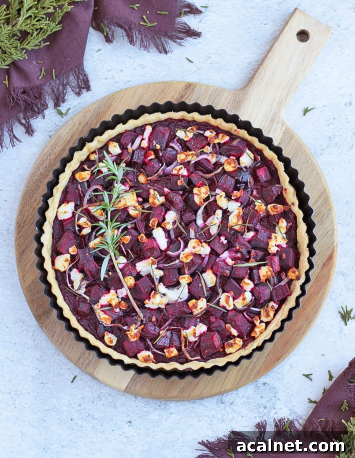Dish from above on a wooden board, highlighting the intricate layers and fresh toppings of the tart.