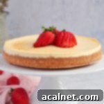 Ricotta Cheesecake on a white cake stand with strawberries