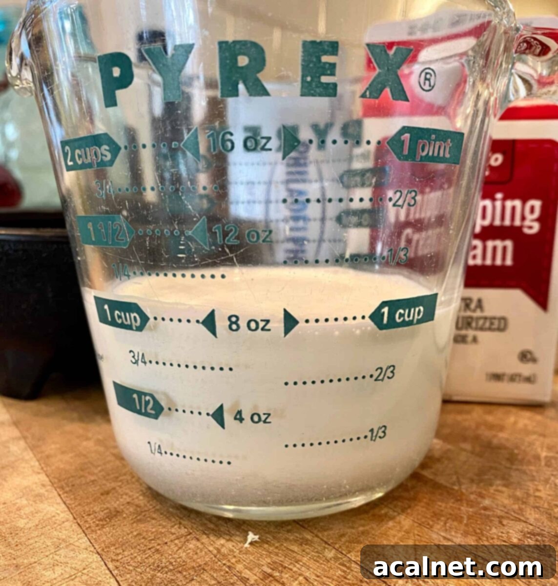 One cup of whipping cream in a glass measuring cup
