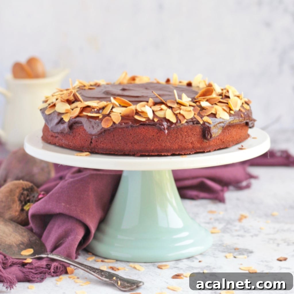 Chocolate Beetroot Cake topped with flaked almonds on a cake stand
