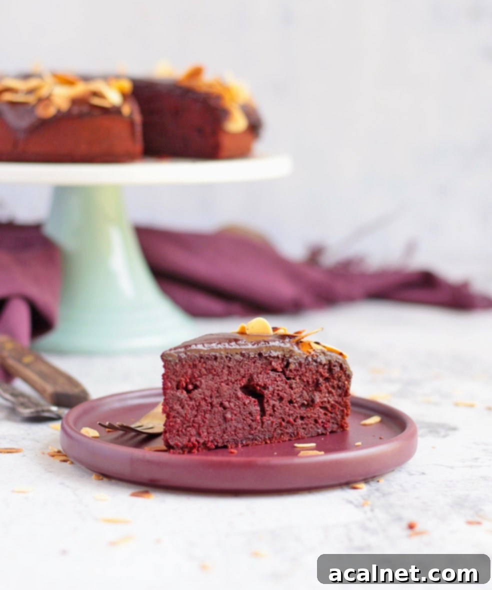 A slice of cake on a purple plate with the cake in the background