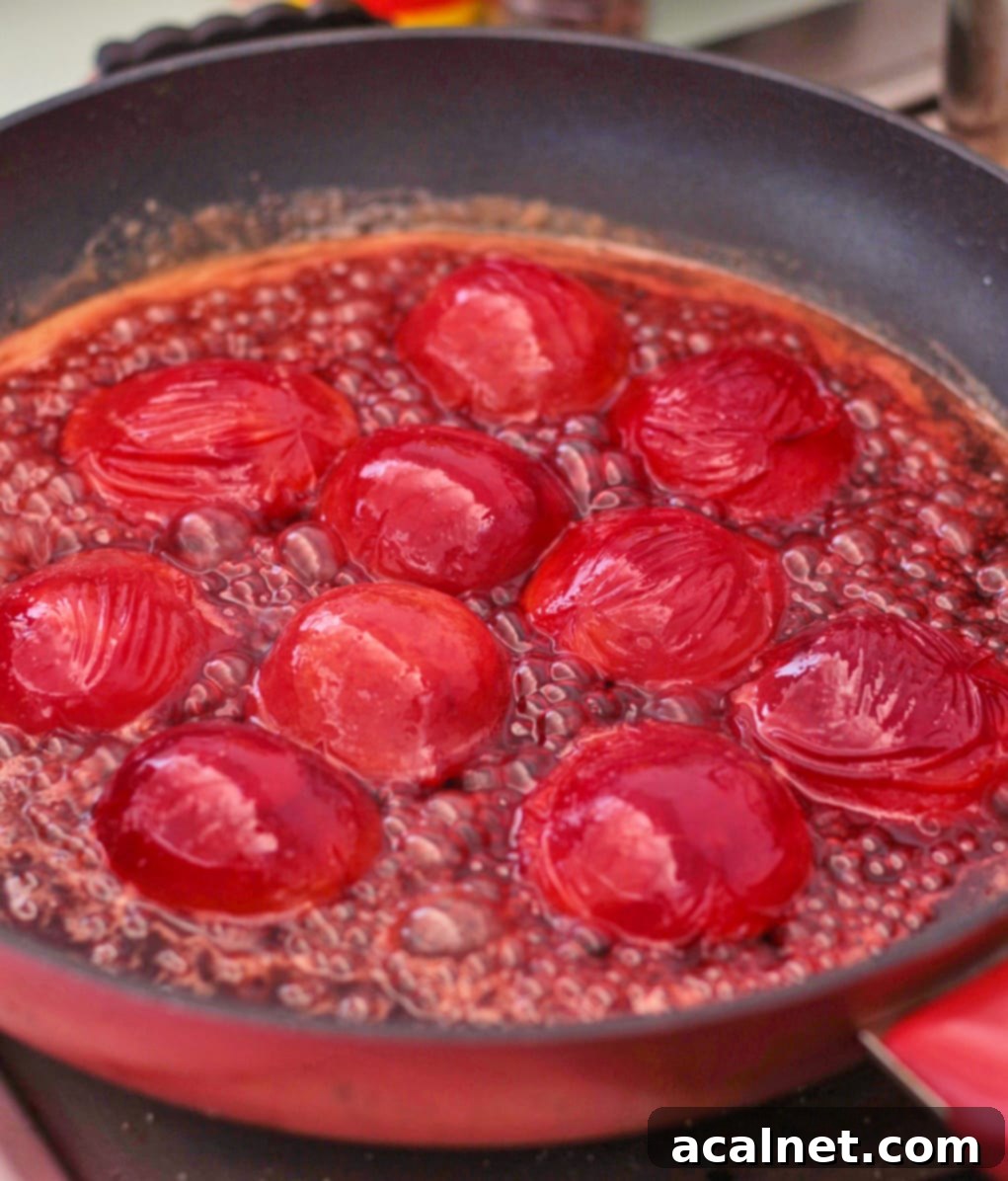 Plums caramelizing in a pan with brown sugar, butter, and lemon juice.