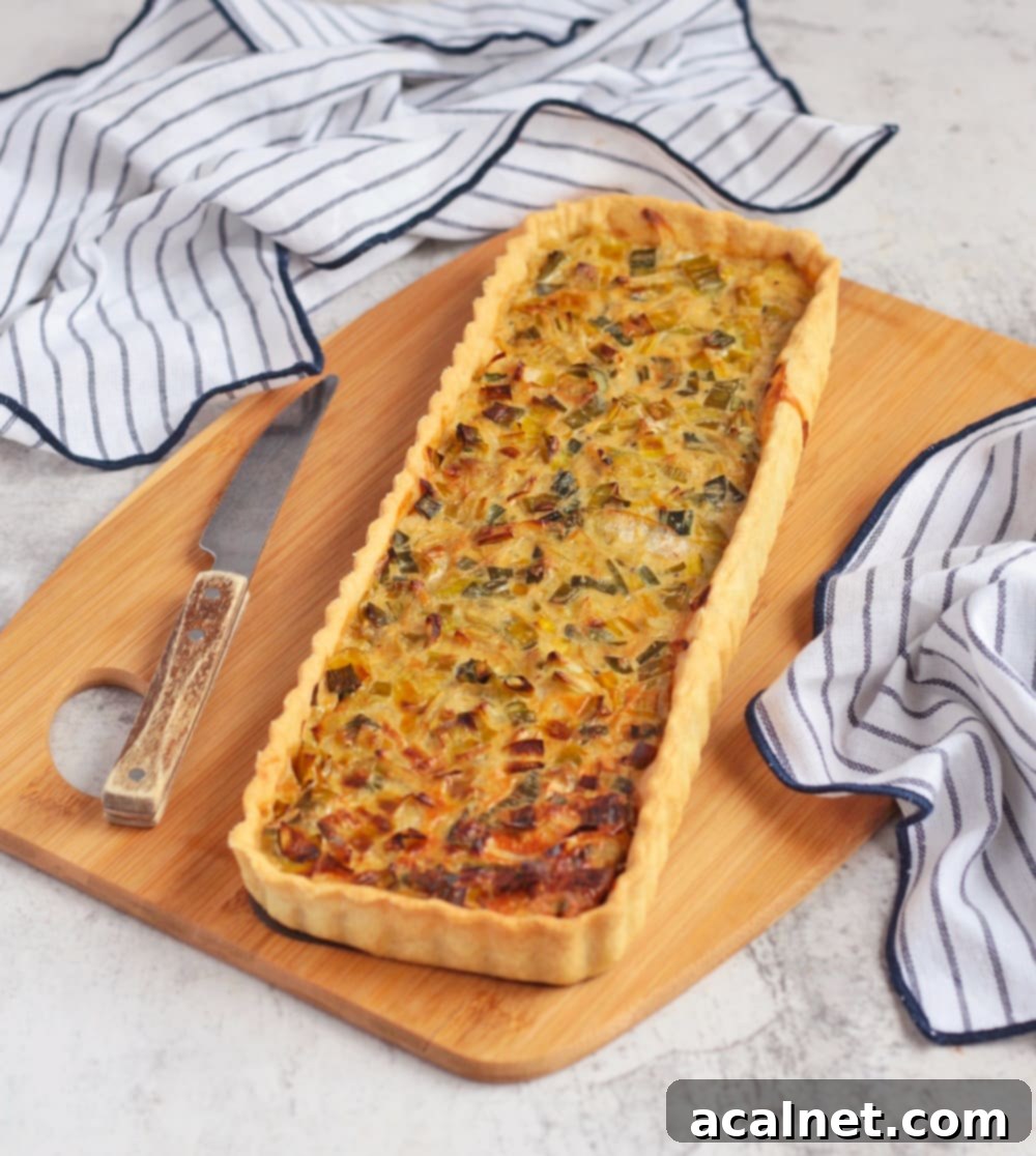 Finished savoury tart on a board with a knife