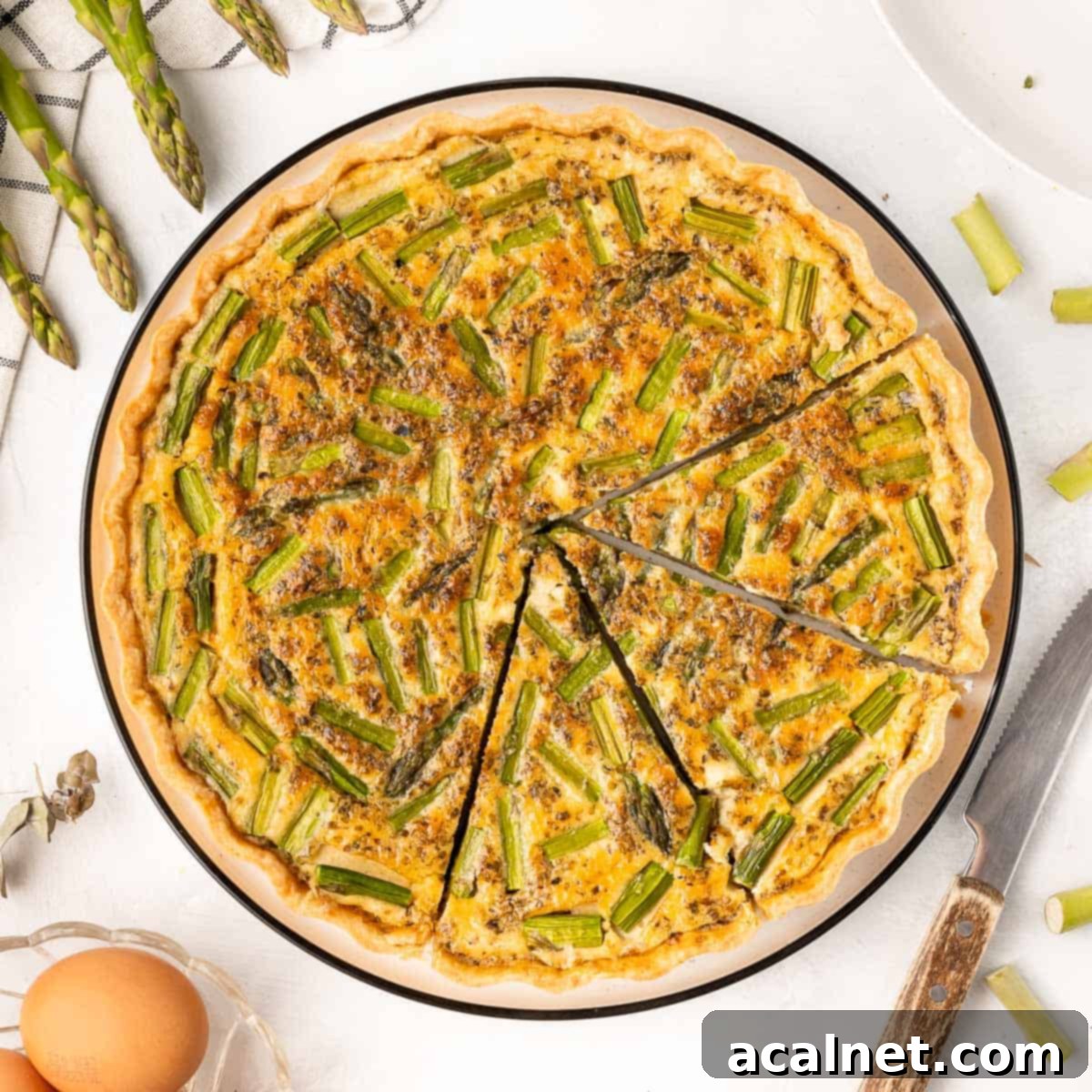 Feta and Asparagus Quiche, shown from above with three slices cut out, revealing the fresh asparagus and creamy feta.