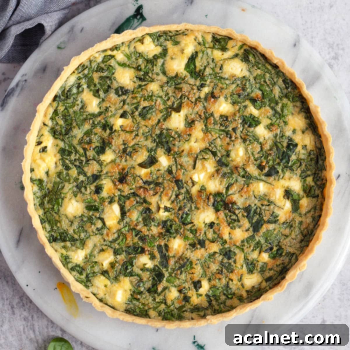 Spinach and Feta Quiche viewed from above, perfectly baked with a golden crust and crumbled feta cheese.