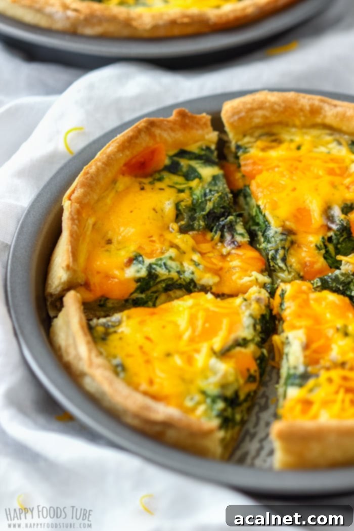 Spinach and Cheddar Quiche with a golden-brown crust and fluffy, cheesy filling.
