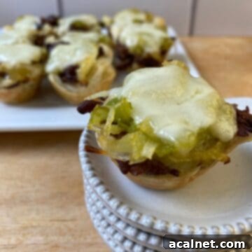 Philly Cheesesteak bite on a small stack of dishes with the serving plate in the background.