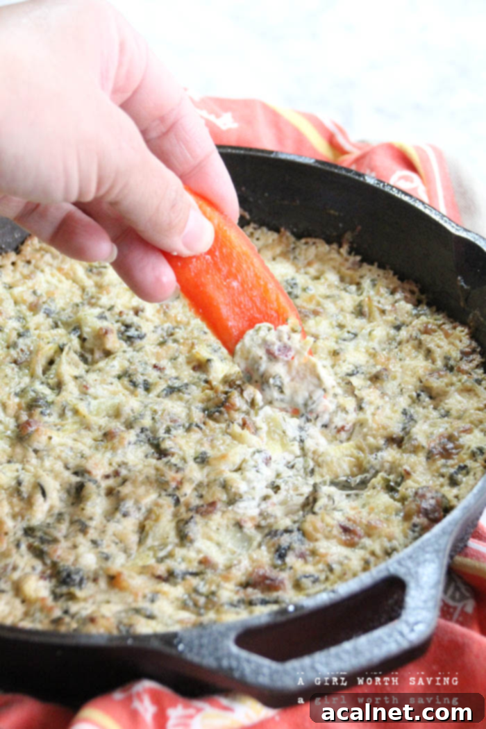 The Best Keto Spinach Artichoke Dip You'll Ever Eat in a skillet, garnished with herbs.