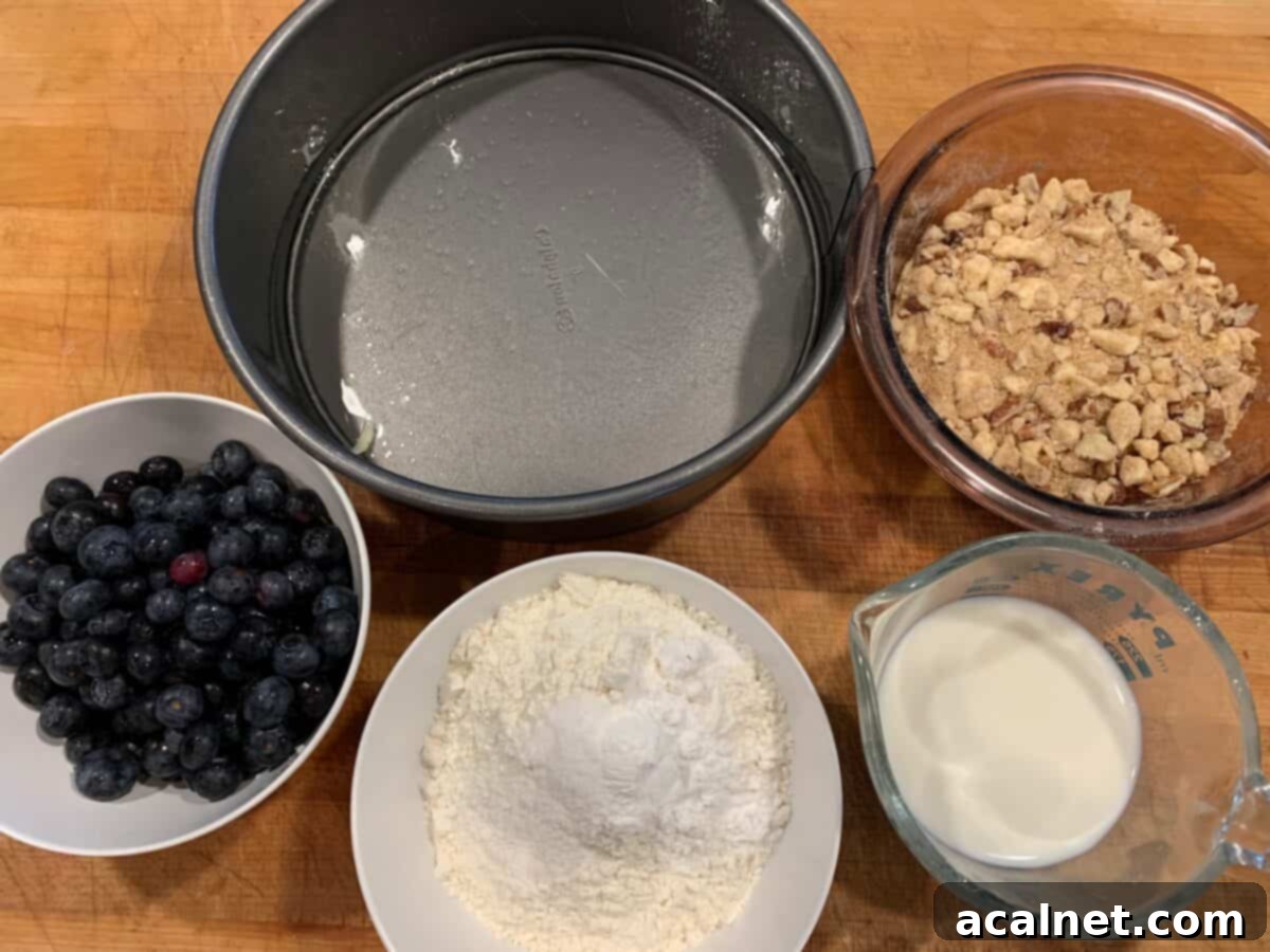 Zesty Lemon Blueberry Coffee Cake 4 Various ingredients for blueberry lemon coffee cake, including fresh blueberries, lemon, butter, flour, and eggs, neatly arranged on a wooden cutting board.