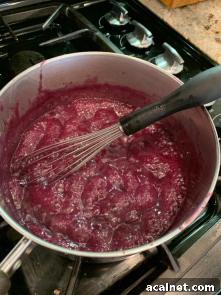 Zesty Lemon Blueberry Coffee Cake 10 Thickened blueberry lemon topping being whisked in a saucepan, ready to be served warm over the coffee cake.