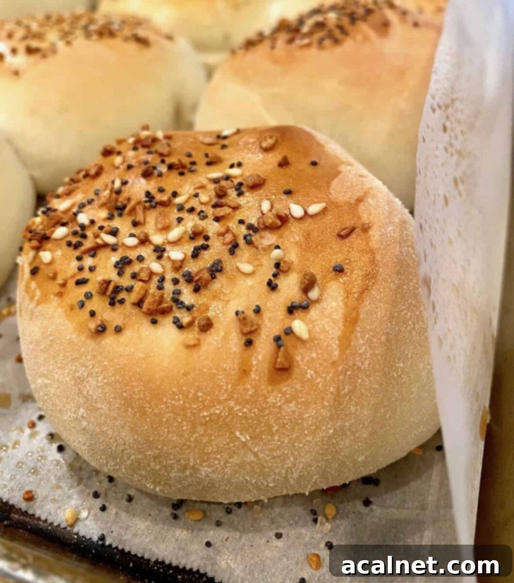 A baked grown-up pig in a blanket resting on a baking sheet, showcasing its golden crust.