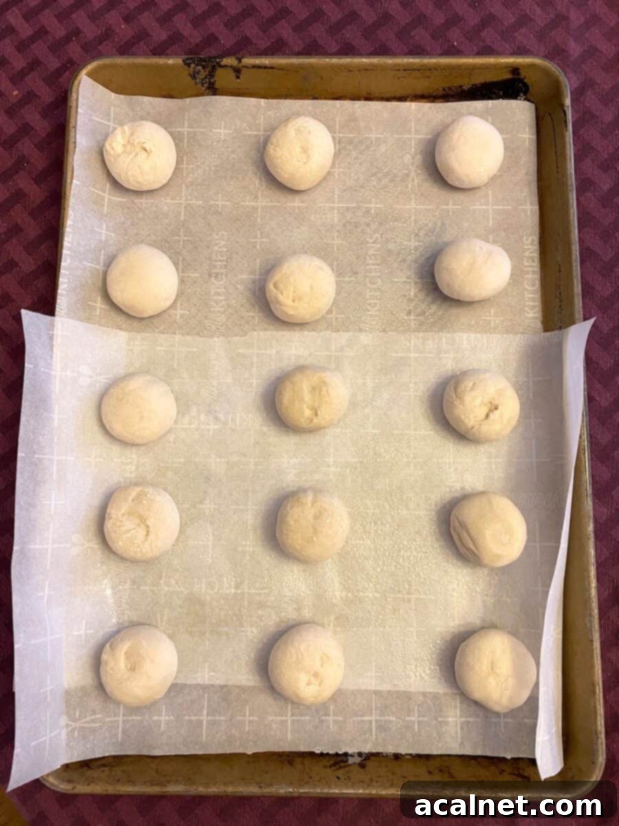 Frozen Rhodes dinner rolls placed in neat rows on a baking sheet, ready for defrosting.