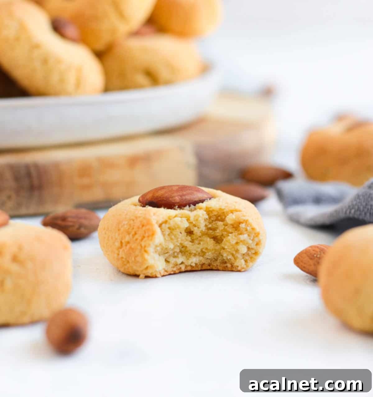 Sadece 3 Malzemeyle Pratik Glutensiz Sütsüz Badem Kurabiyesi 4 A cookie with one bite taken off.