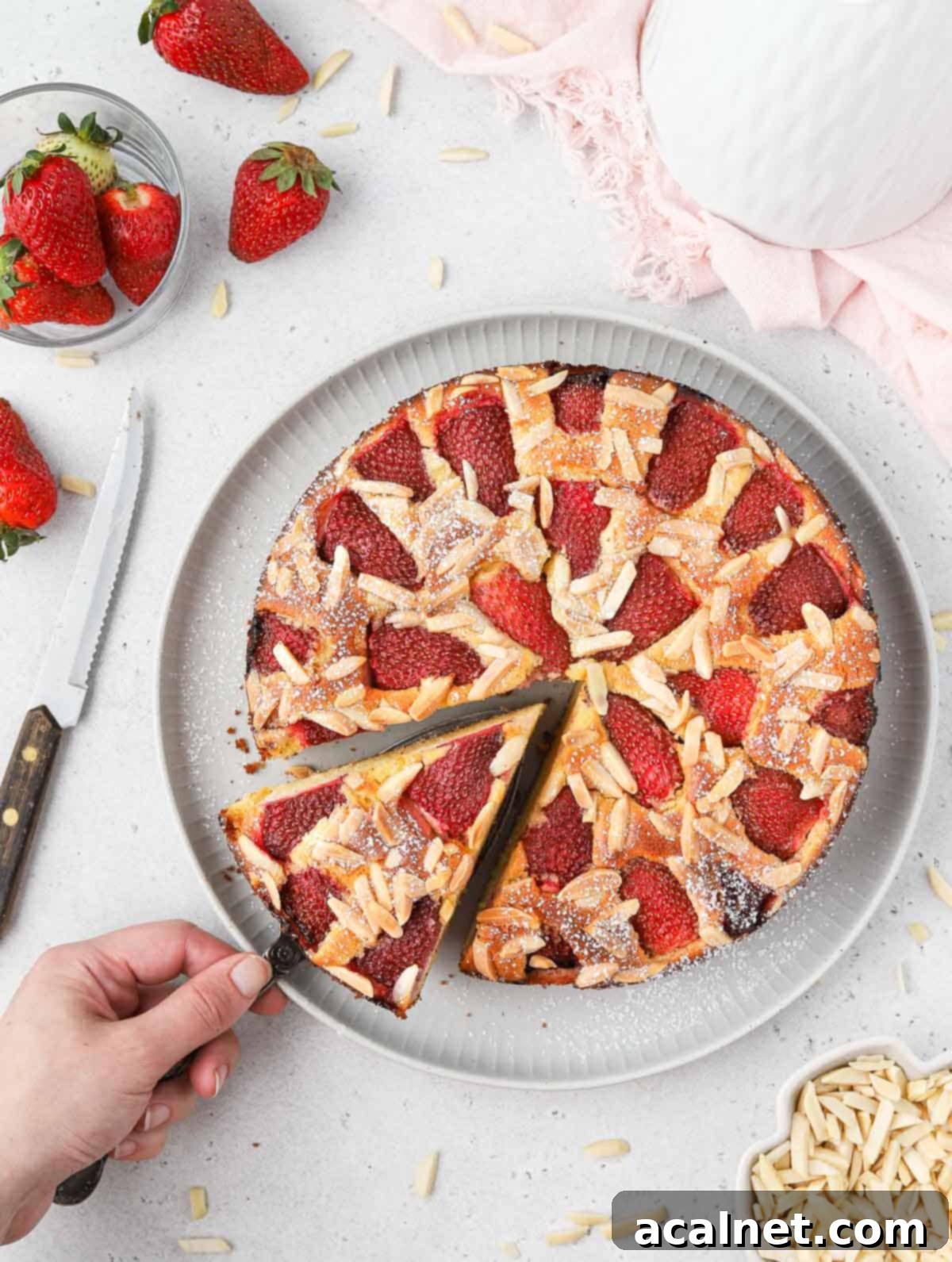 Almond Strawberry Bliss Cake Gluten Free 8 Picking up a slice of cake flatlay.
