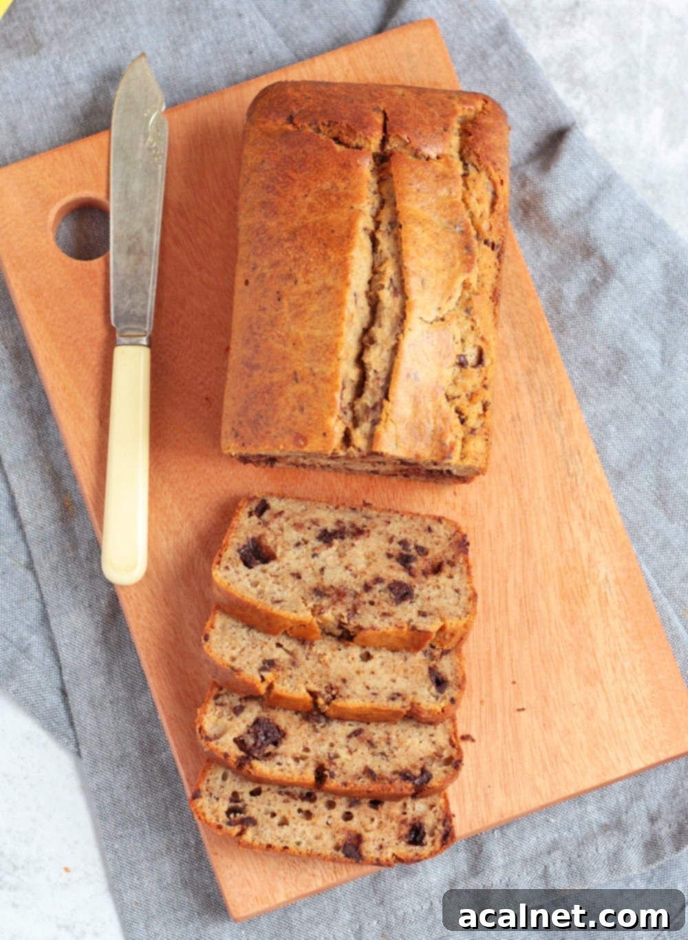 Overhead shot of a sliced banana bread, highlighting the golden crust and dark chocolate chunks.