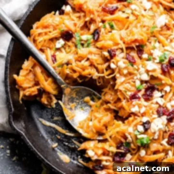 Braised cabbage and apples in a skillet with a spoon
