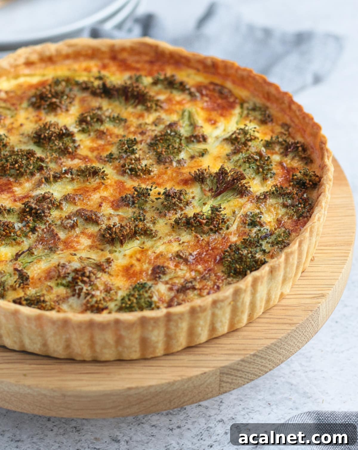 Side view on the quiche, showing layers of flaky crust, creamy filling, and tender broccoli.