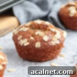 One oatmeal banana muffin next to the muffin pan