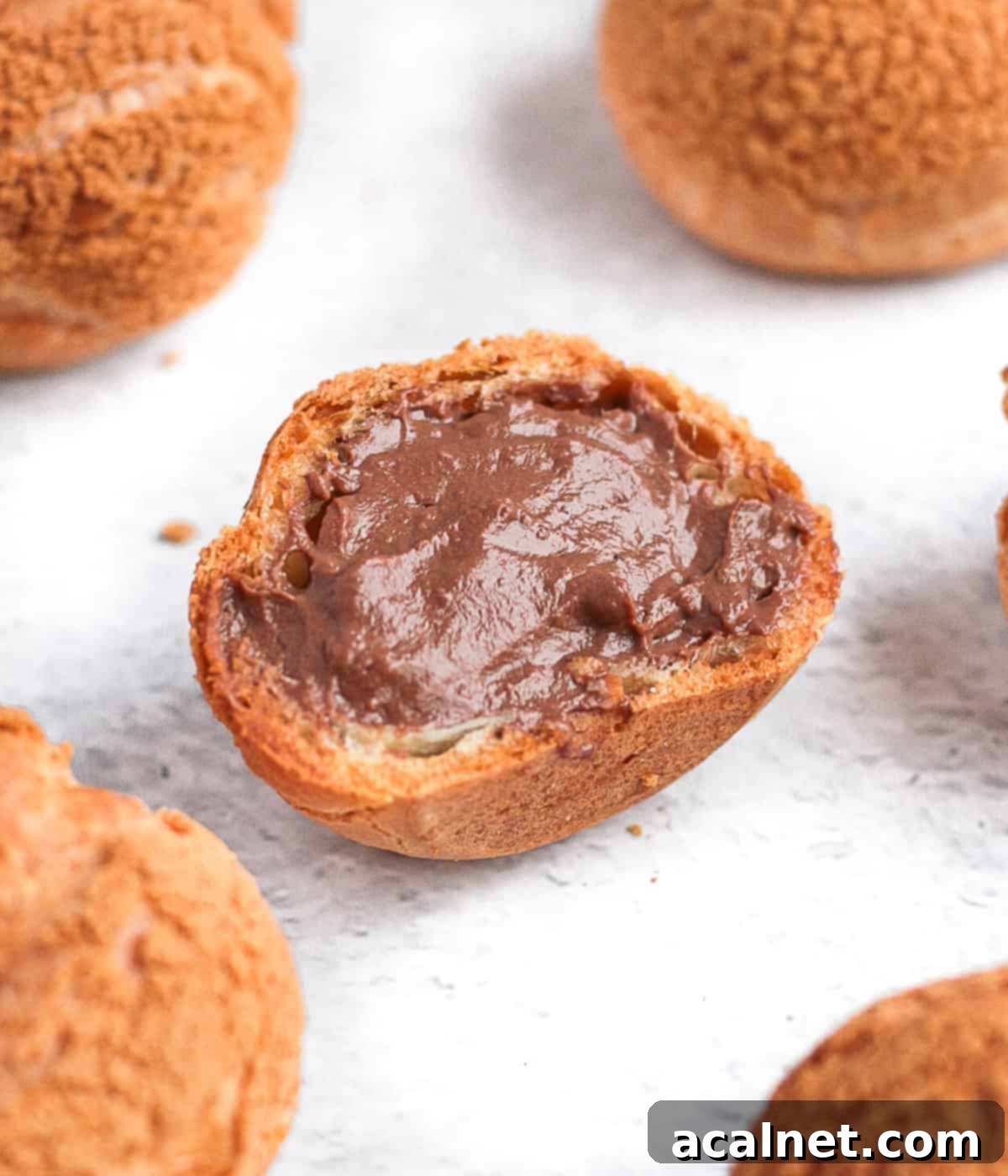 Choux sliced in half and filled with chocolate pastry cream.