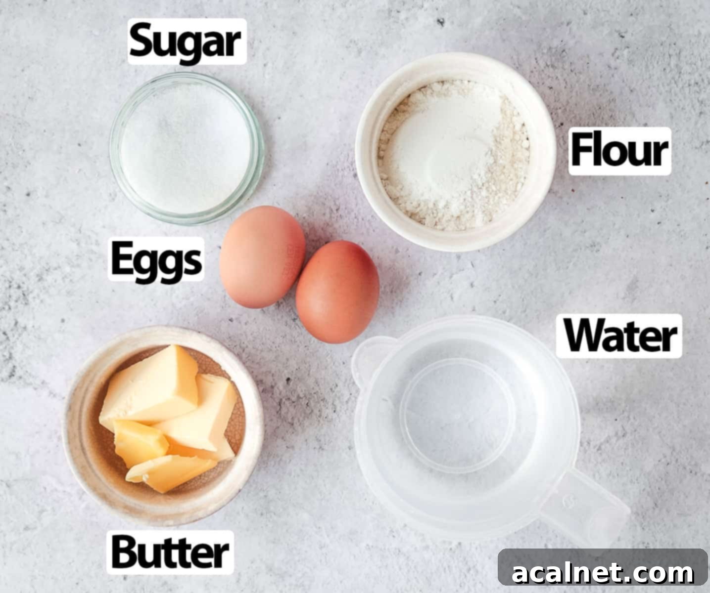 Ingredients for choux pastry on a light grey surface.