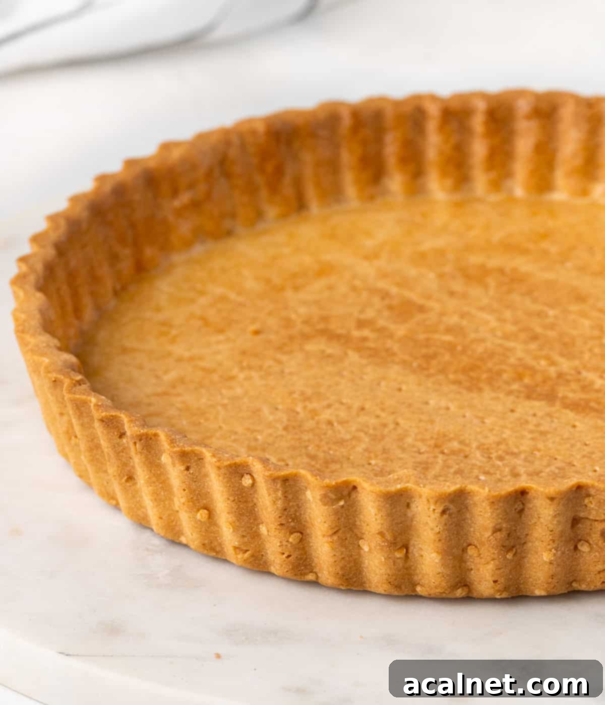 Side view on the perfectly baked, golden-brown edges of a Pâte Sucrée crust, showing its crisp texture.