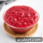 Stewed Rhubarb in a glass bowl over a wooden plate