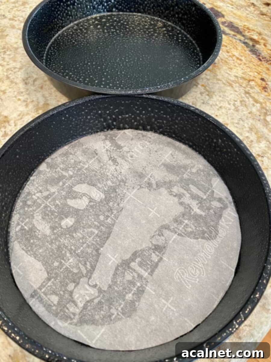 Two round baking pans, one lined with parchment paper. 