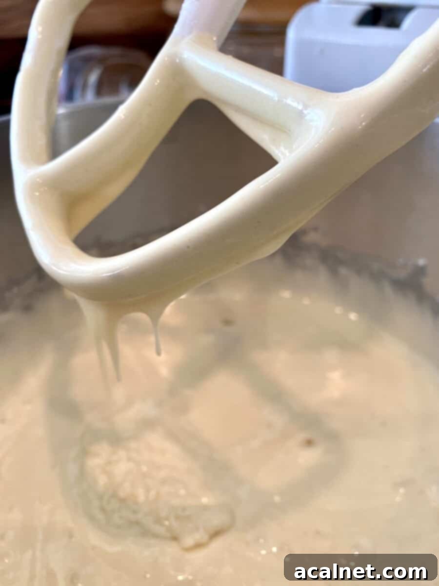 Cake batter in a mixing bowl with a beater. 