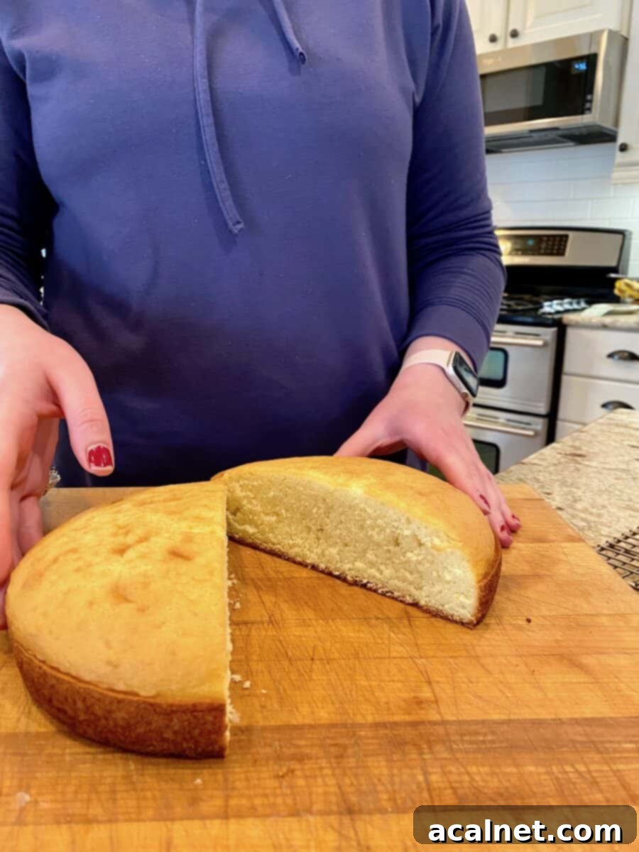 Cake round cut in half on a cutting board.