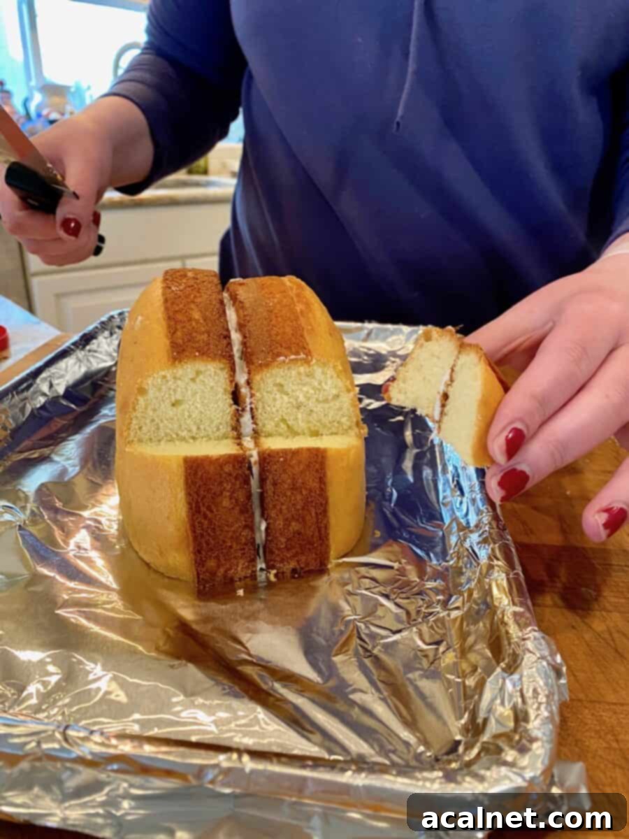 A wedge of cake cut from two baked cake rounds placed on a foil lined baking sheet. 
