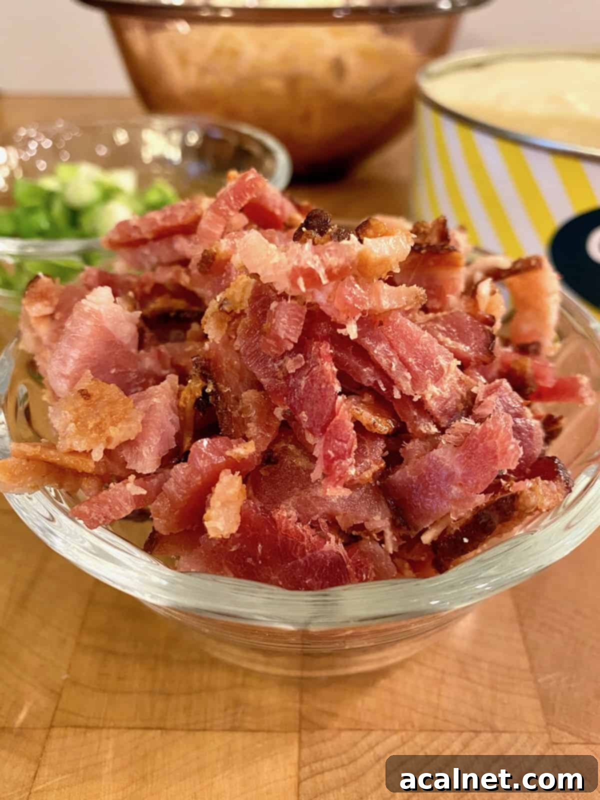 A bowl of cooked and diced bacon, prepared for the quiche.