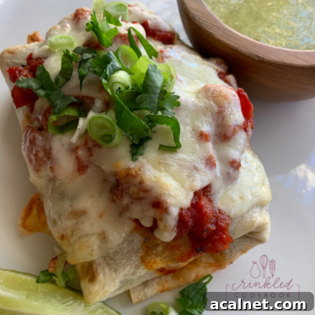 baked burrito on a plate with lime on the side