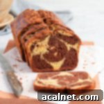 Effortless Swirled Loaf Cake 9 Cake on a wooden board with one slice down