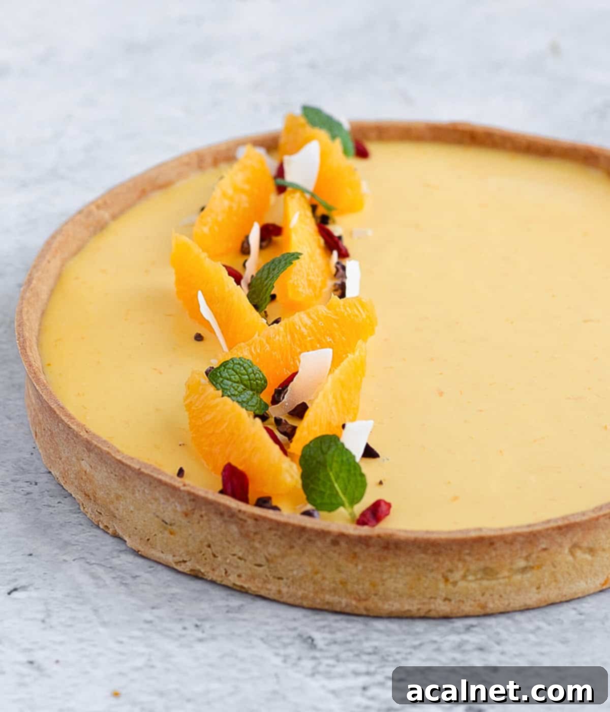 Close up on the orange segment topping over the tart.