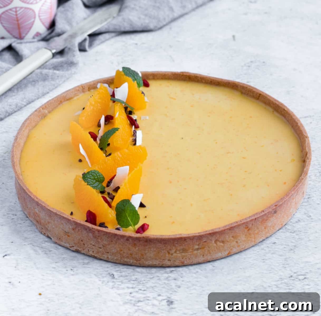 Decorated tart on a light grey surface.