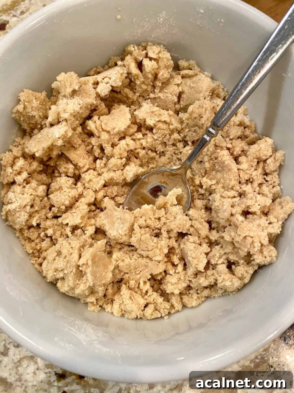 The streusel topping ingredients fully combined in a small bowl, forming a perfect coarse, crumbly mixture with small butter clumps, ideal for muffin tops.