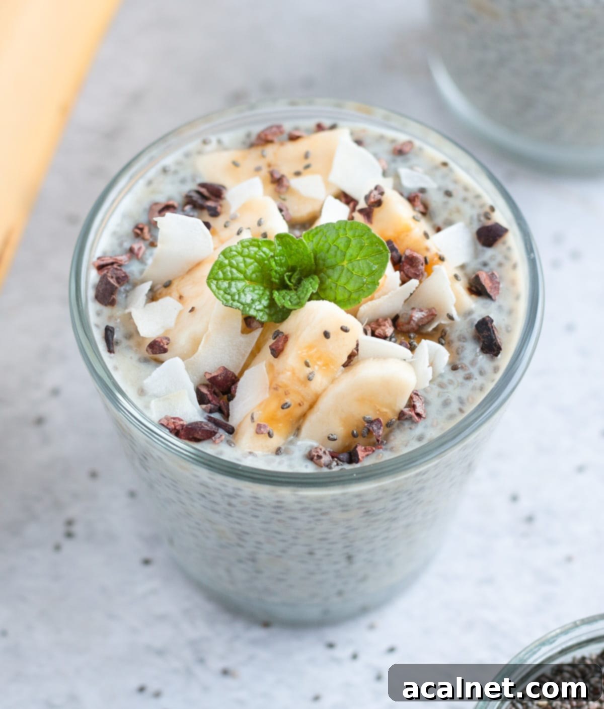 Close up on the toppings over the banana pudding, including coconut, bananas and cacao nibs