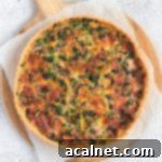 Flatlay of the quiche over white baking paper on a round wooden board