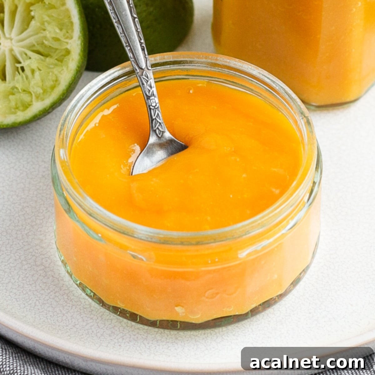 Close up on a glass jar with the coulis and a silver spoon.