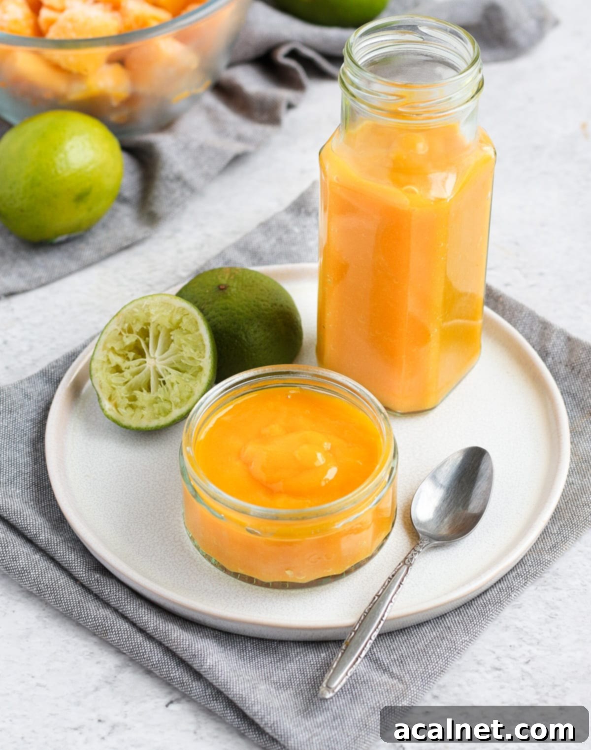 Coulis in a glass jar and glass cup on a white plate