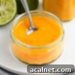 Close up on a glass jar with the coulis and a silver spoon