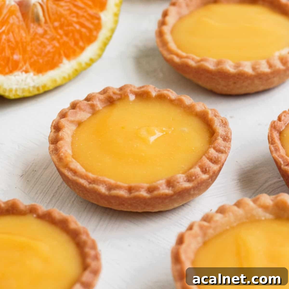 A close-up of a single old-fashioned frosted orange cookie, showing its soft texture and creamy icing.